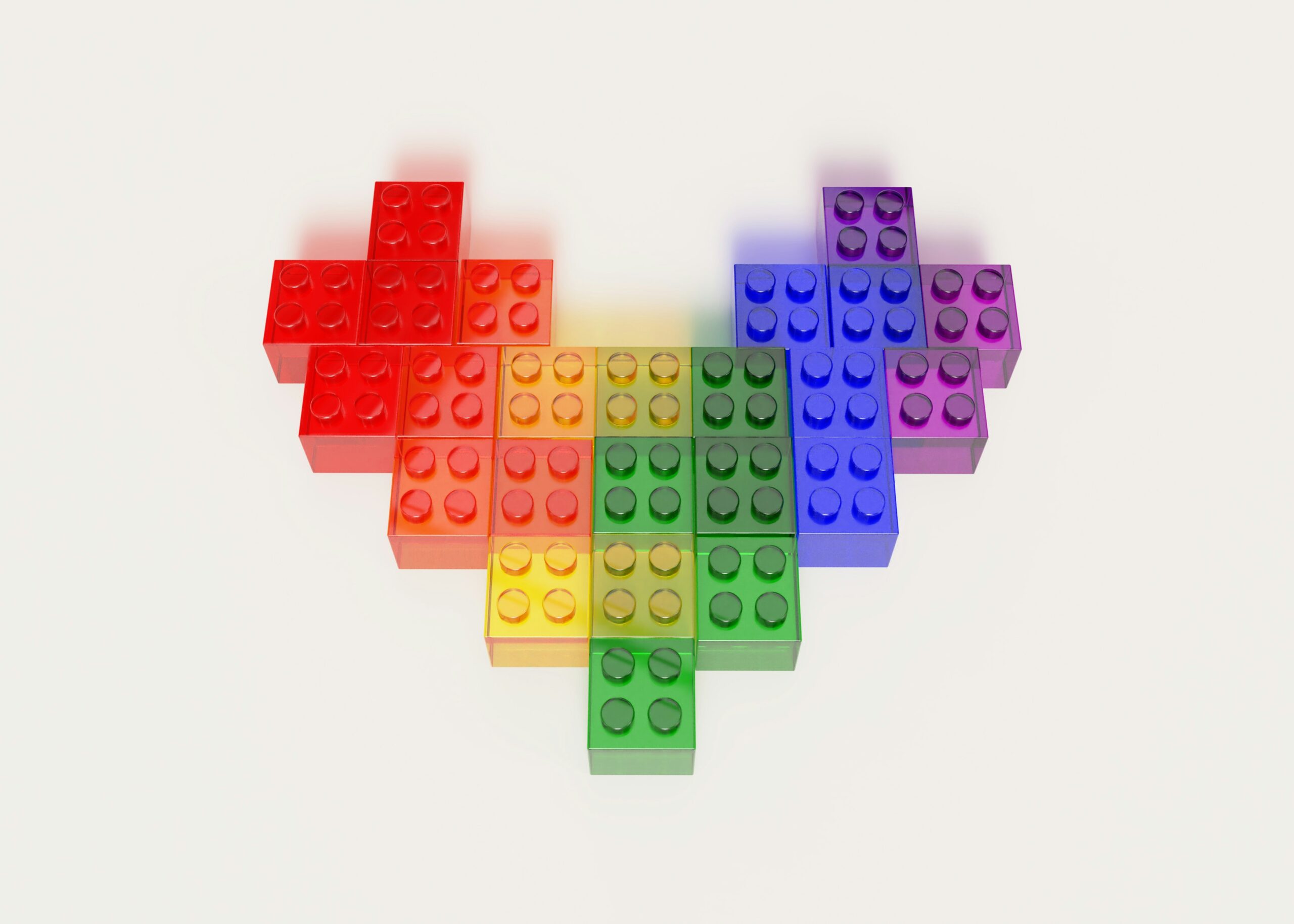 Heart shape made from colorful LEGO bricks arranged on a white background