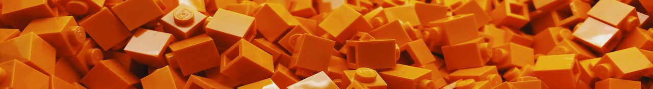 Close-up of orange LEGO bricks piled together in a horizontal banner image