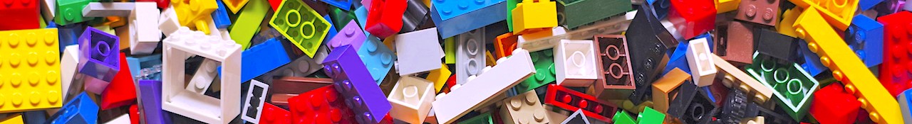 Colorful assortment of LEGO bricks piled together in a horizontal banner image